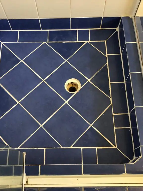 After: The same shower base with the floor retiled in a diamond pattern