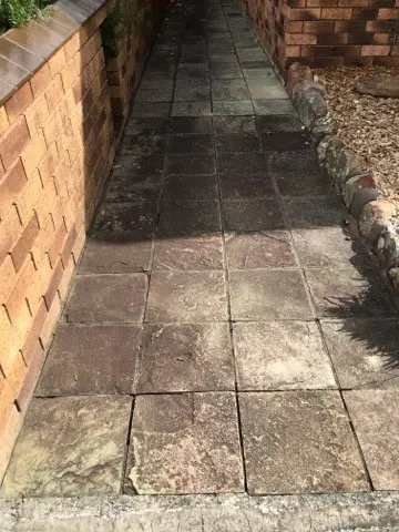 Before: Garden path of stone-look tiles, weathered and darkly stained
