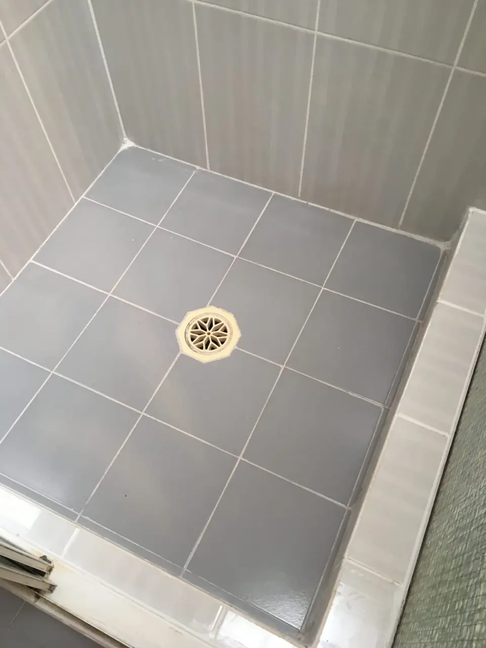 After: The same shower with renewed grout and white sealant lines
