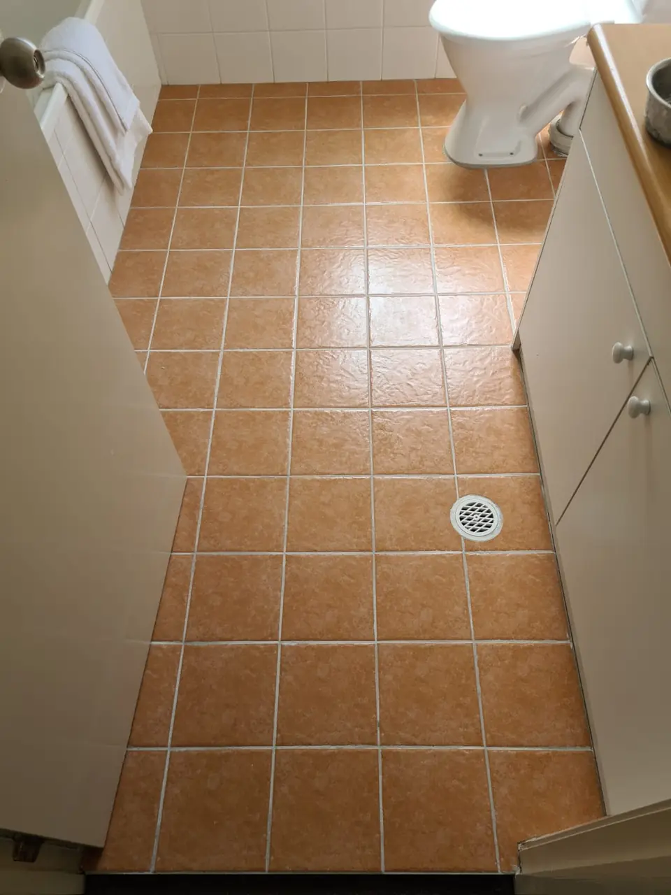 After: The same bathroom floor with fresh light grout